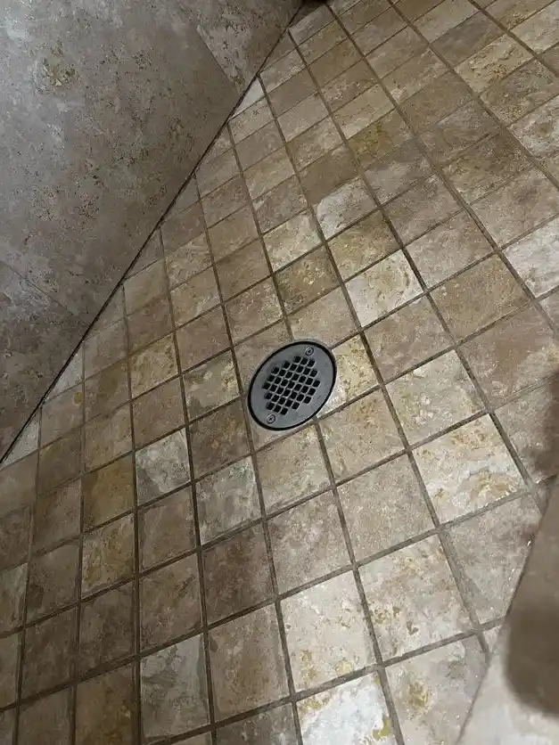 The same tiled shower floor with clean tile and grout, after cleaning