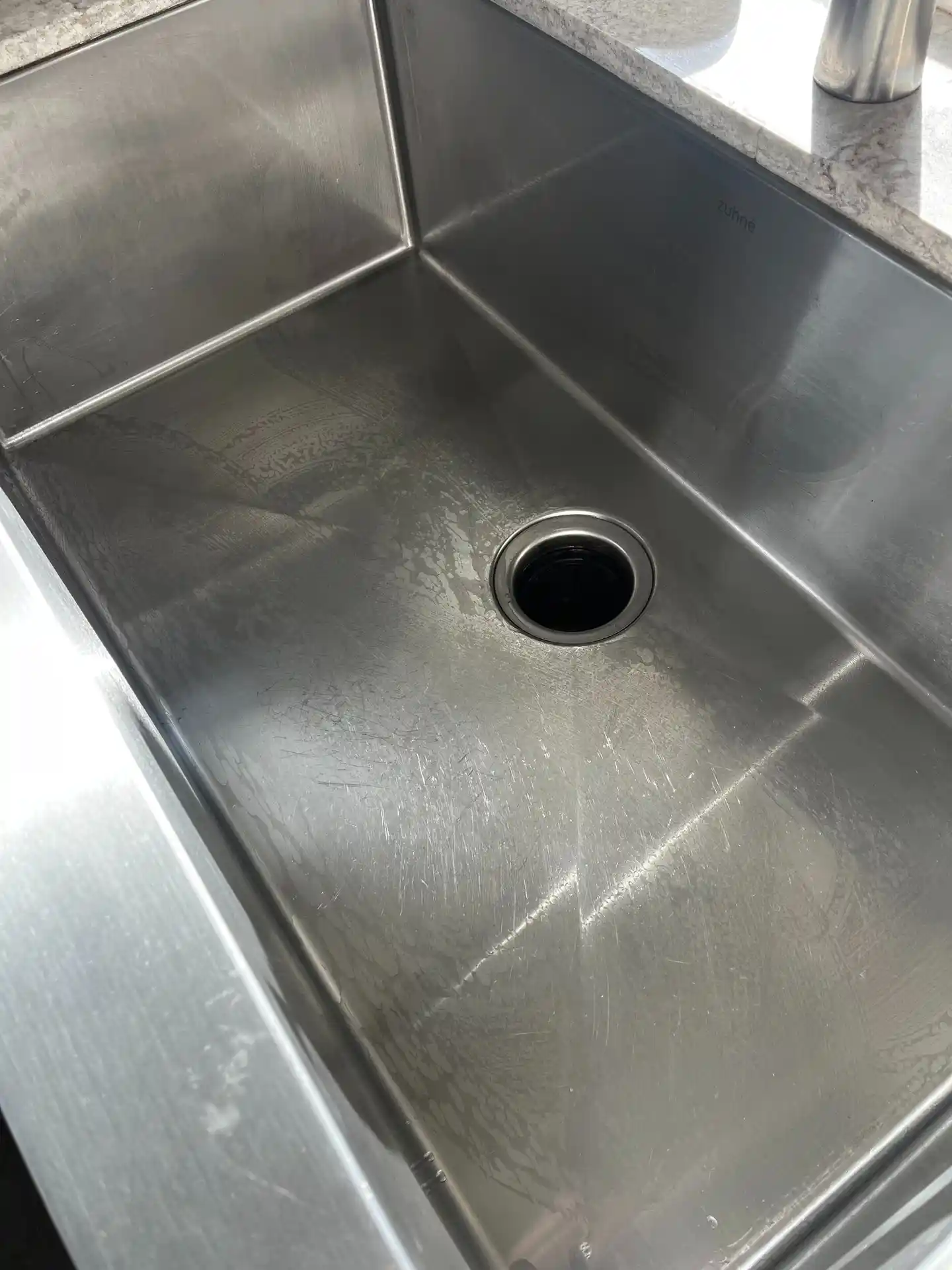 The same stainless steel kitchen sink gleaming, after cleaning